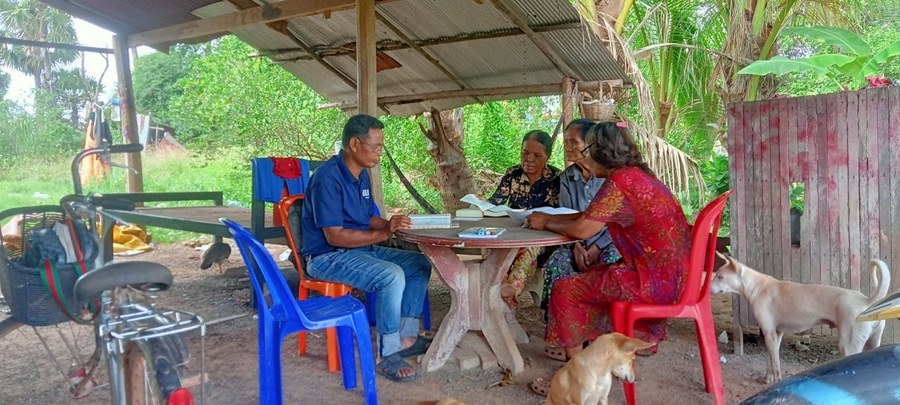 Pastor PenRa studying the Bible with community members in Chhuk