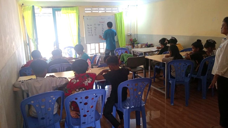 A teacher leading the English class on the whiteboard in Chouk Va Mouy